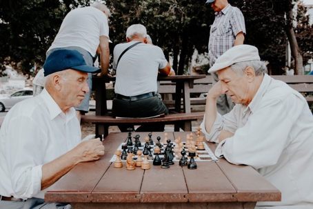 elderly men outside playing chess